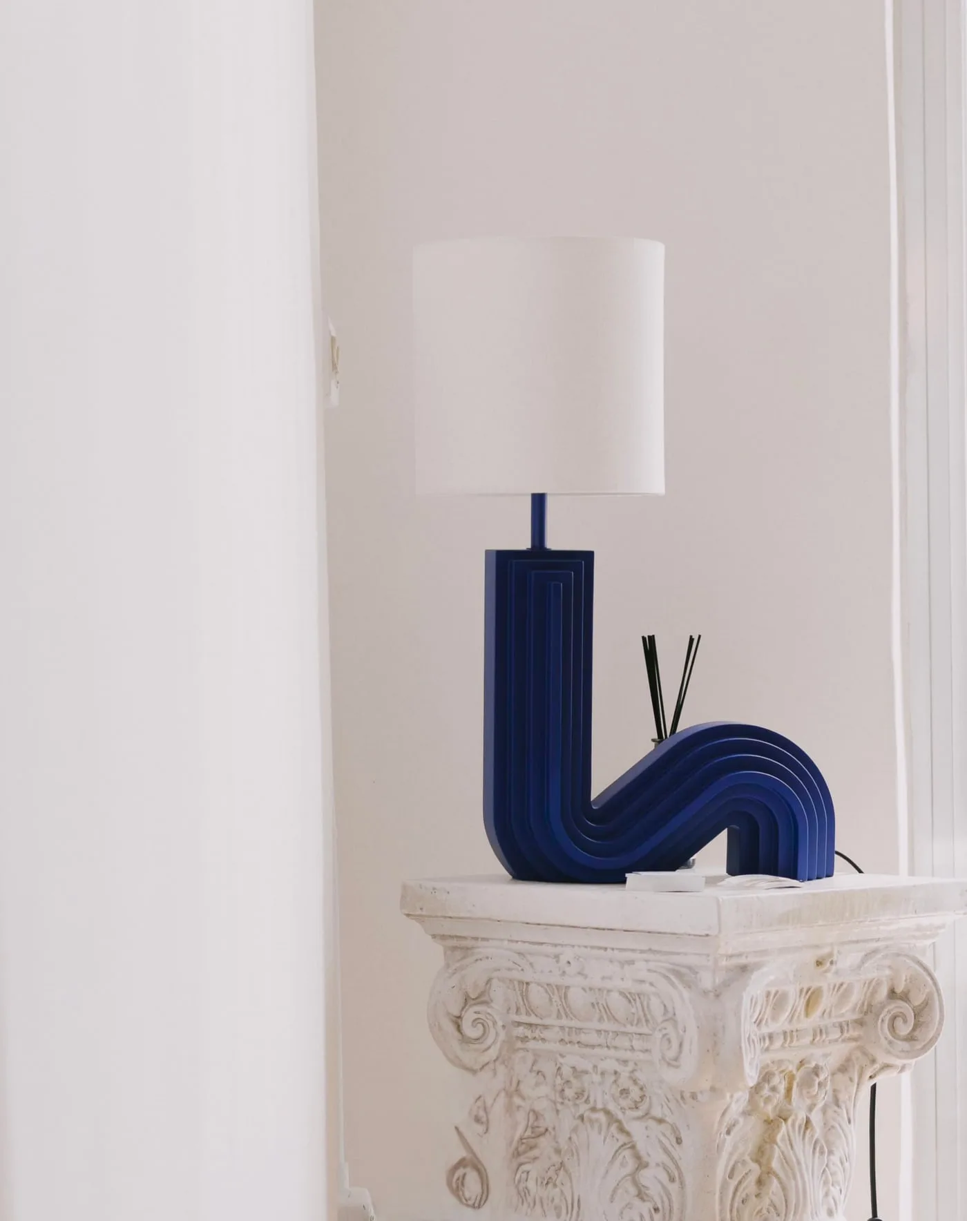 La lampada in ceramica blu sul capitello in gesso