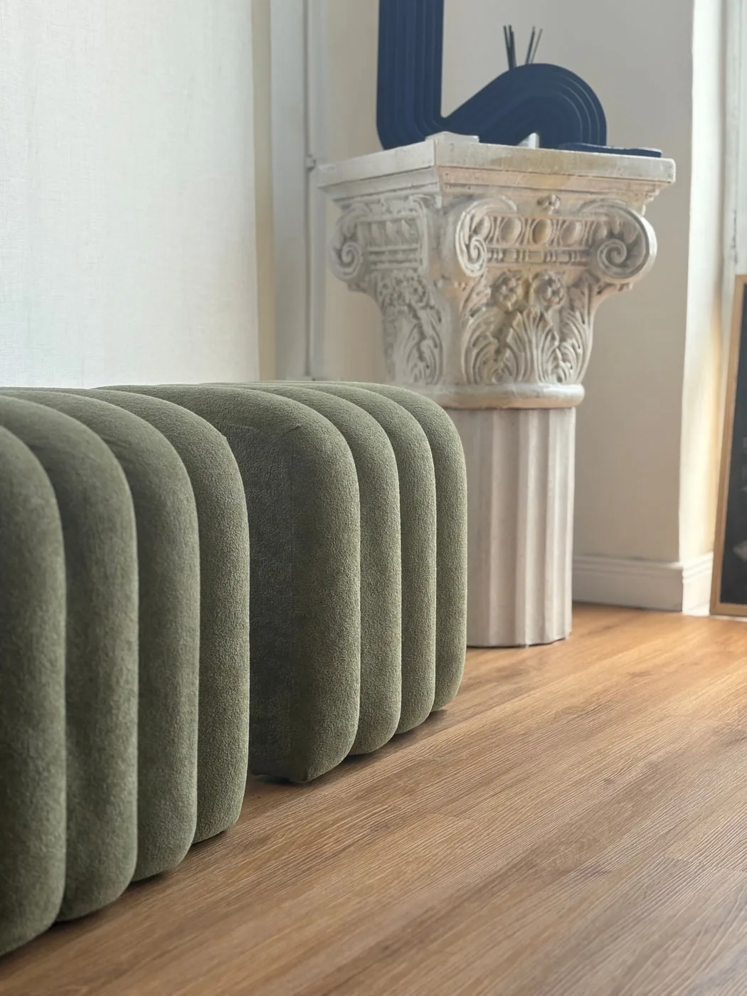Il pouf di velluto salvia davanti al capitello